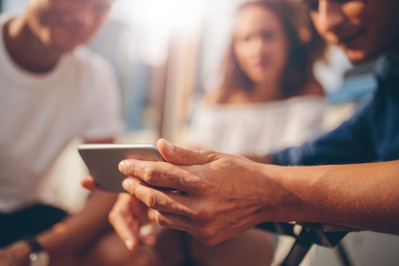 A man showing video on mobile device to friends