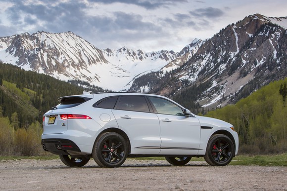 A white Jaguar F-PACE SUV with mountains in the background.