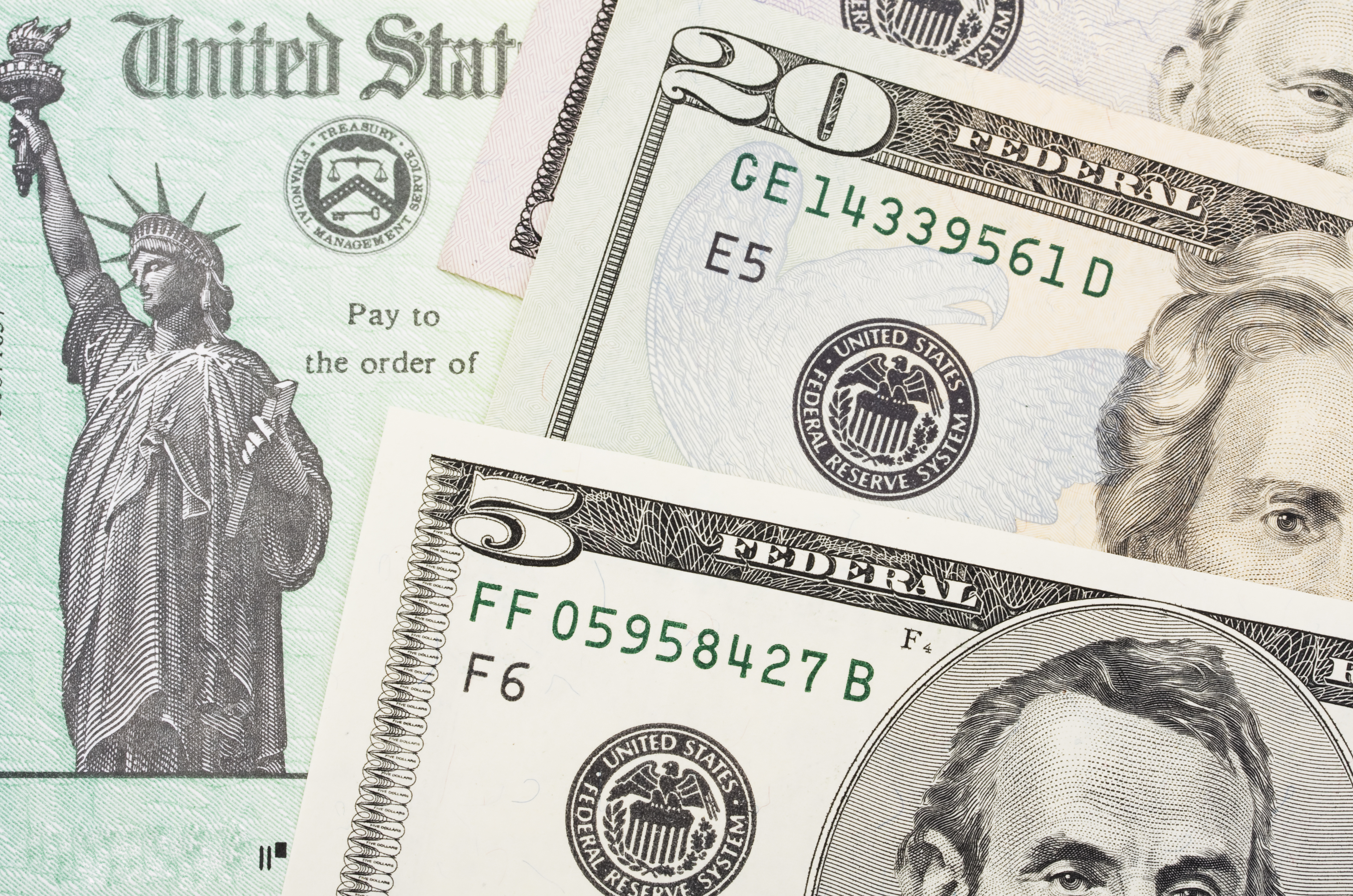 U.S. currency on top of a tax refund check.
