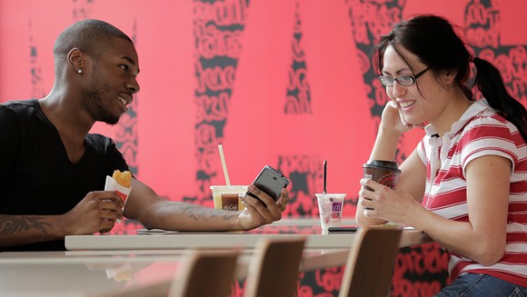 A young couple sits in a McDonald's restaurant.