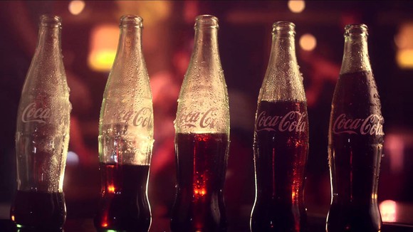 Coke bottles with different amounts of liquid in them.