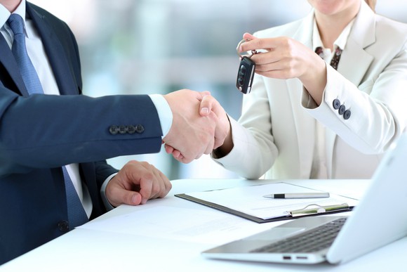 A car buyer is handed her keys.