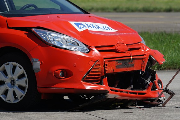 A red car with a crushed front.