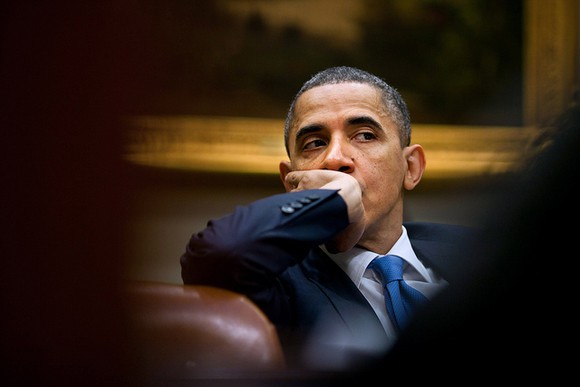 Now-former President Obama listening at a meeting with his staff.