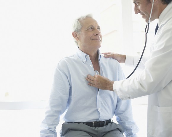 Doctor examining older male patient.