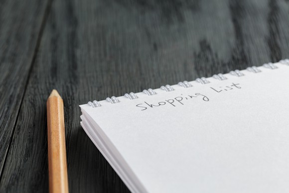 a pencil next to a note pad, with "shopping list" written on it.
