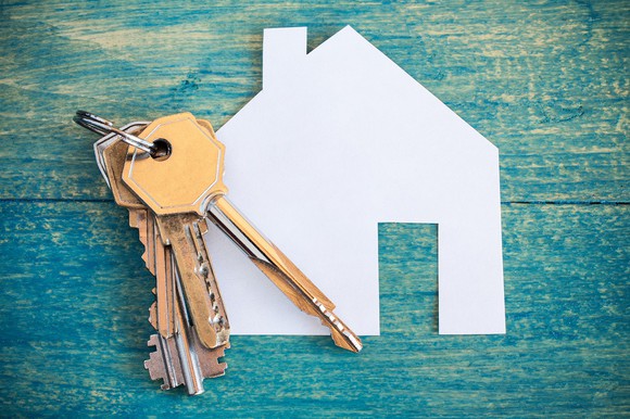 Keys on top of paper house cutout.
