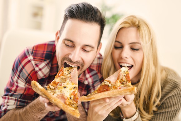 Couple eating pizza slices