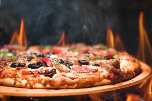 Wood-fired "everything" pizza in front of flames