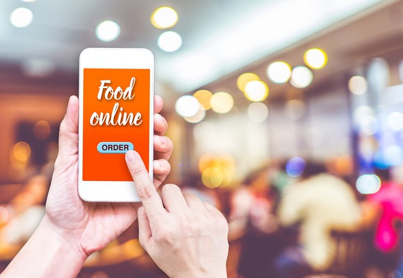 Person using smartphone to order food online.