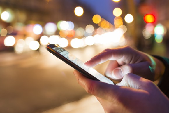 Man using cell phone on a street.