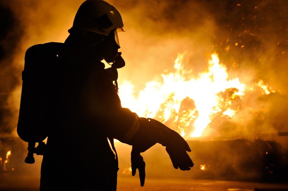 Fireman in silhouette against flames.