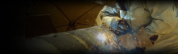 Welder working on a pipeline fitting.