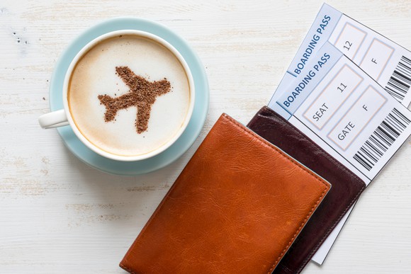 Cappucino cup with airplane art in foam, boarding passes.