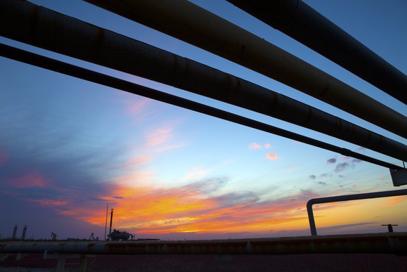 Oil pipelines over a sunset.