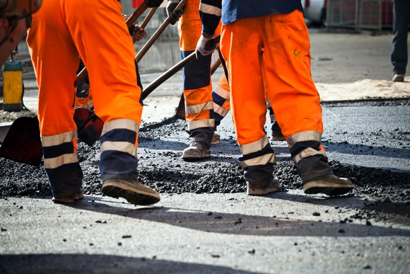 Road workers tearing up road