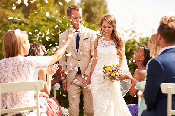 Bride and groom being showered with confetti