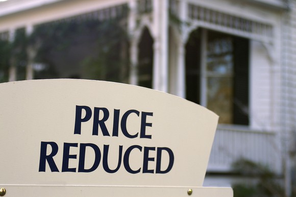 Home for sale with price reduced sign.
