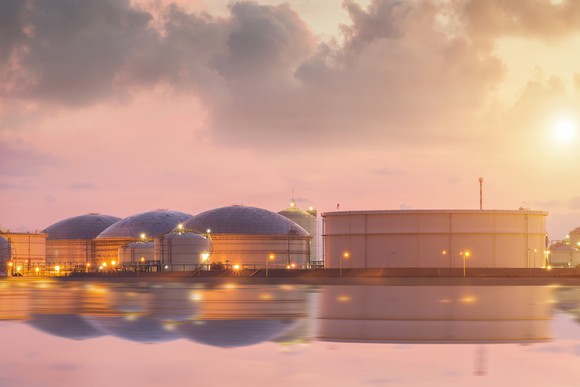 Petroleum product storage tanks reflecting on the water.