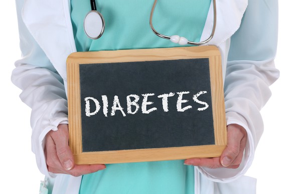 Healthcare worker holding a chalkboard that says "DIABETES"