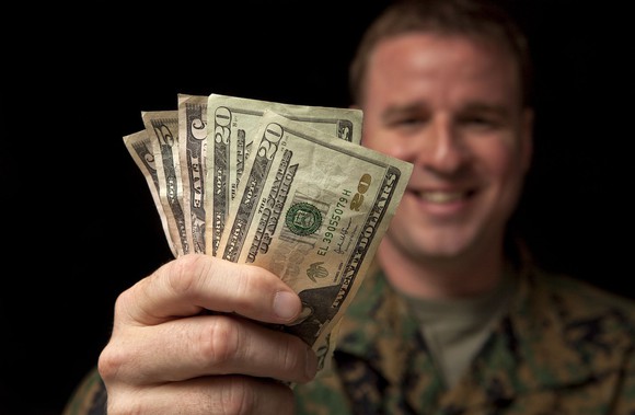 Military servicemember with handful of money