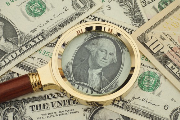 Magnifying glass aimed at dollar bills