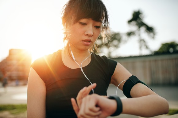 A woman uses her fitness wearable during a workout.