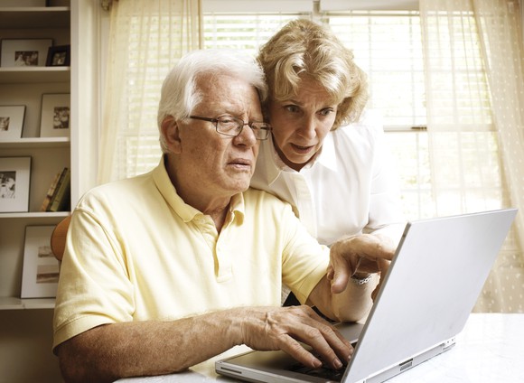 A senior couple making comparisons on their laptop.