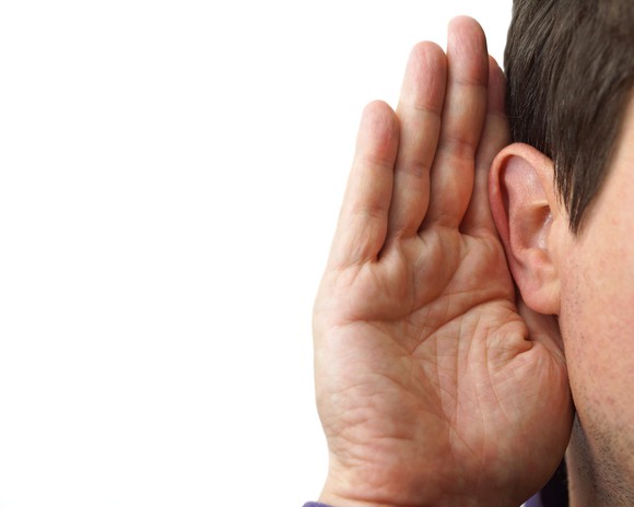 Businessman with hand cupped on ear to listen