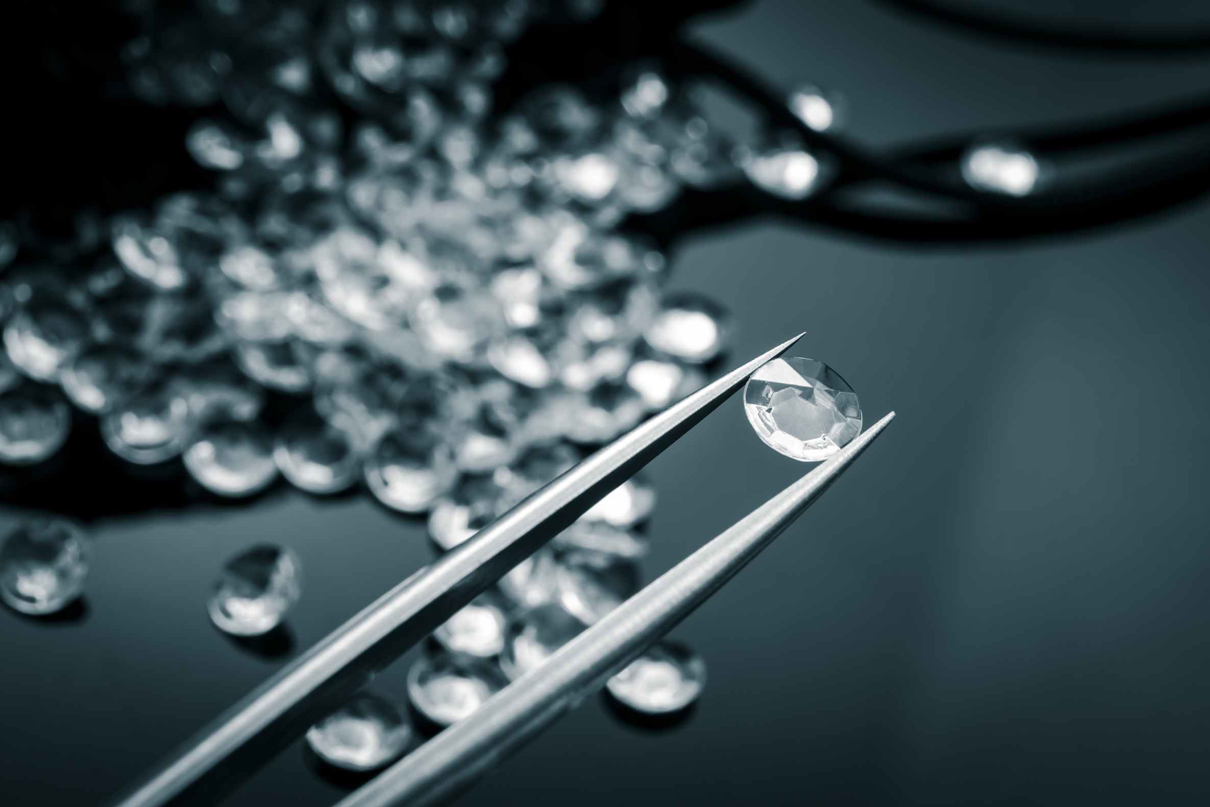 Worker examining a pile of diamonds.