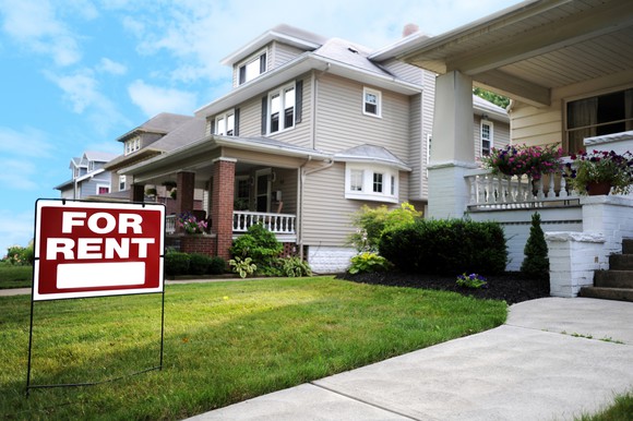 Single-family home with for rent sign in lawn.