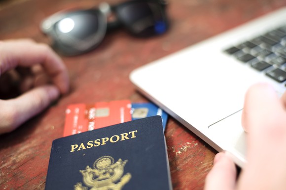 Passport on desk using a laptop