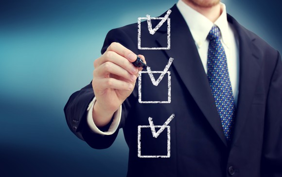 A businessman ticks off boxes on a checklist.
