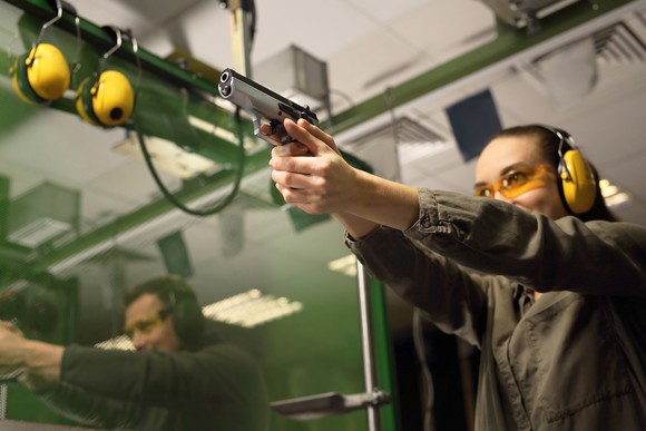Woman target shooting at a gun range