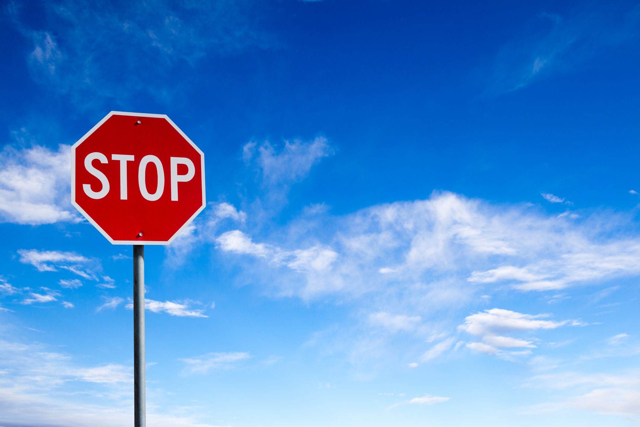 Picture of stop sign with sky in the background.
