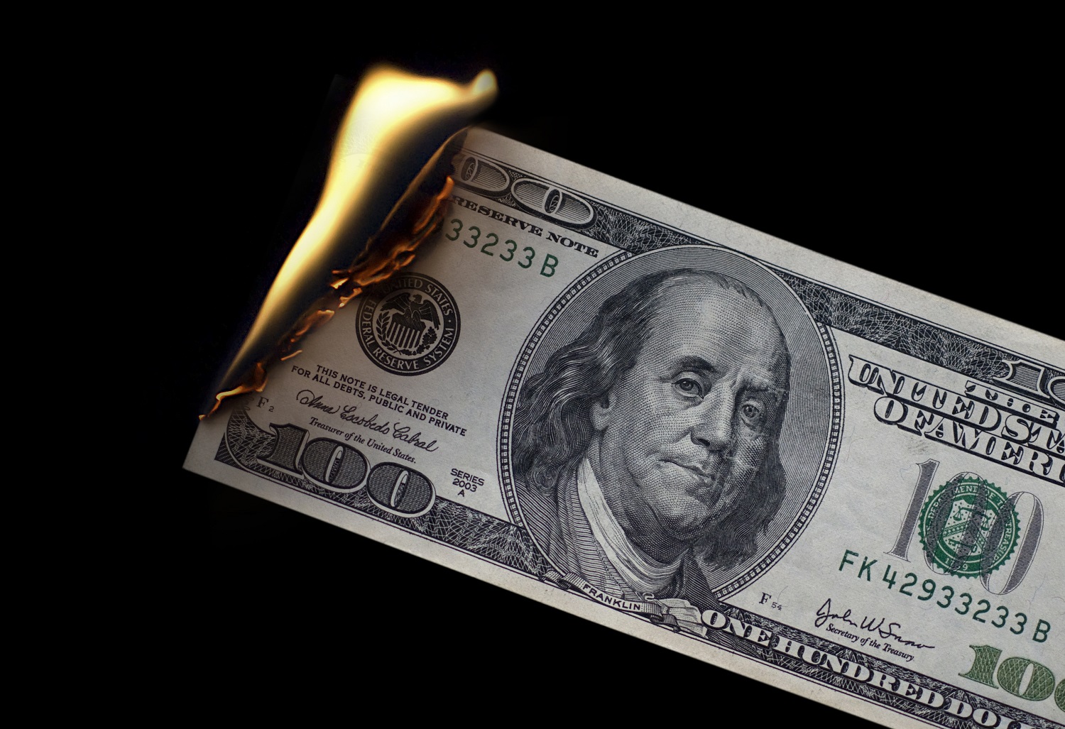 $100 bill on fire.