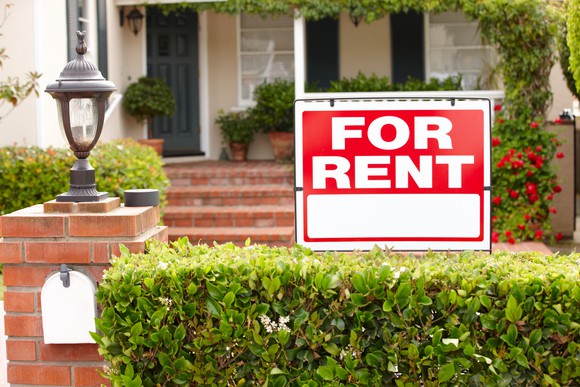 House with a "for rent" sign in the front yard.