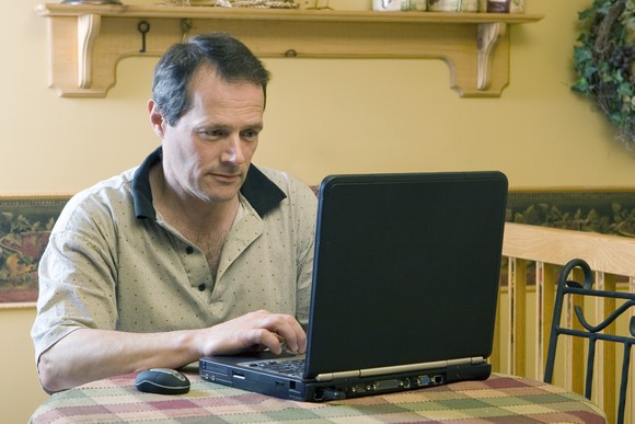 Older man working on laptop from home
