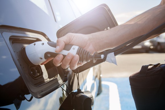 A person plugging in an electric vehicle.