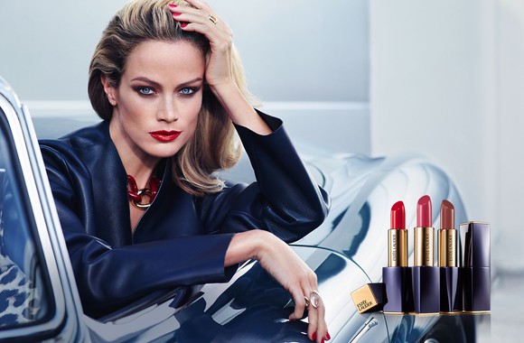 A woman leaning out of a parked car, showing off Estee Lauder lipstick.