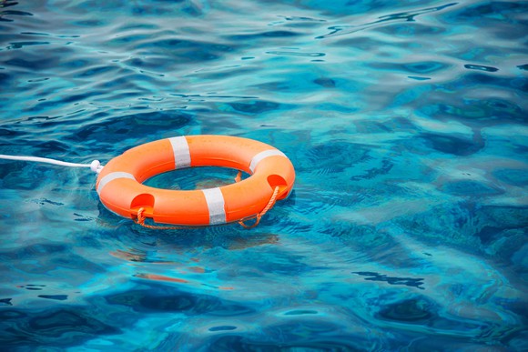 Orange life preserver floating in blue water.