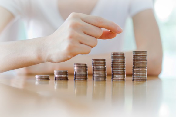 A woman stacking quarters up in ascending rows.