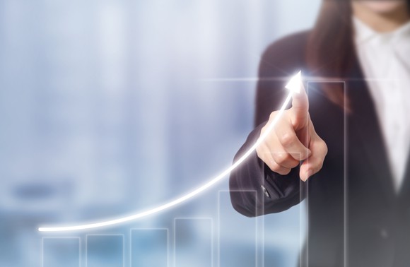 Woman pointing at an upward trending curve.