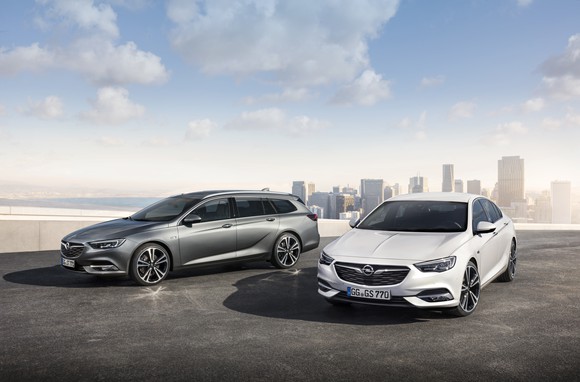 Two 2018 Opel Insignias, a wagon and a 5-door, are shown with a city in the background.