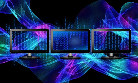 Three computer monitors displaying code.