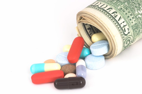 Pills coming out of a roll of money