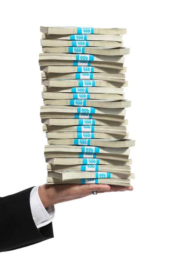Hand holding a large stack of cash.