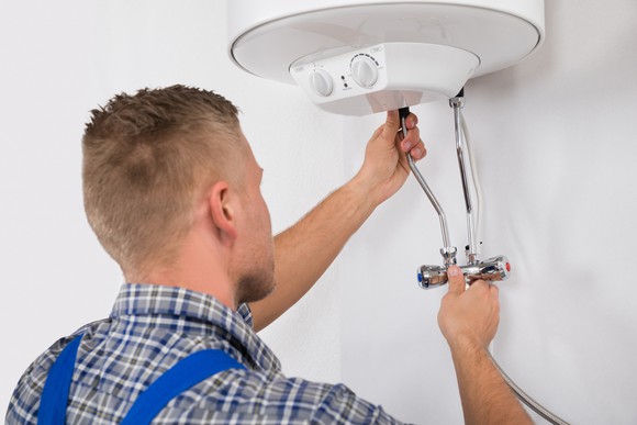 Worker fixing an electric boiler.