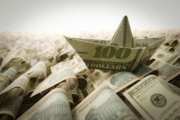 Ship made from a $100 bill in a sea of money