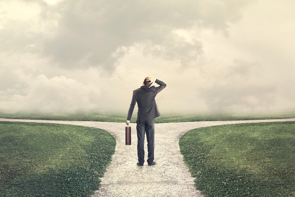 business man standing at road that splits